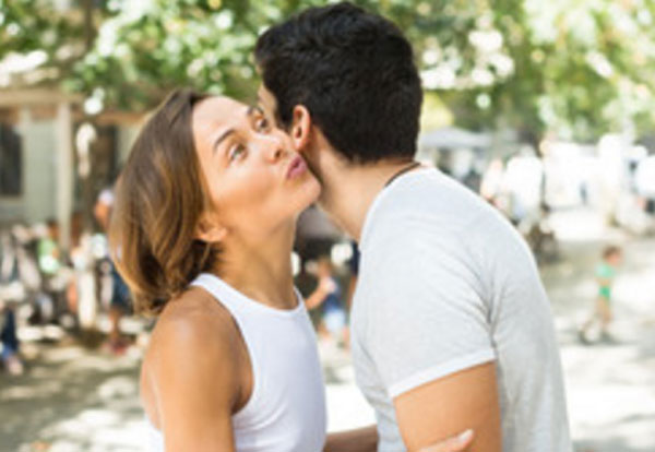Девушка целует в щечку мужчину