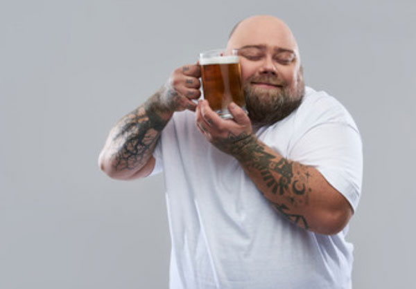 Мужчина прижимает к себе бокал пива