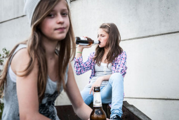 Две девочки сидят со спиртным, одна пьет с горла