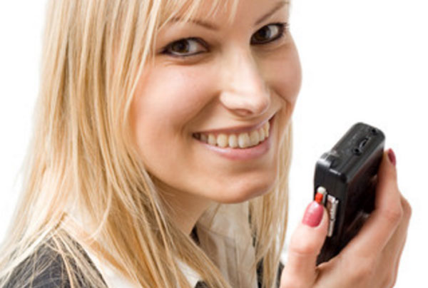 Улыбающаяся женщина держит в руках диктофон