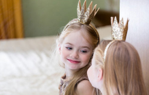 Маленькая принцесса смотрит в зеркало