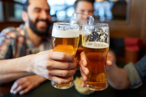 Мужчины поднимают бокалы с пивом