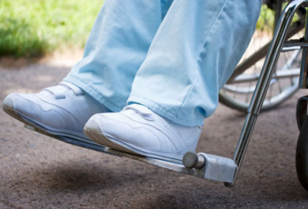 Ноги человека, сидящего на инвалидной коляске