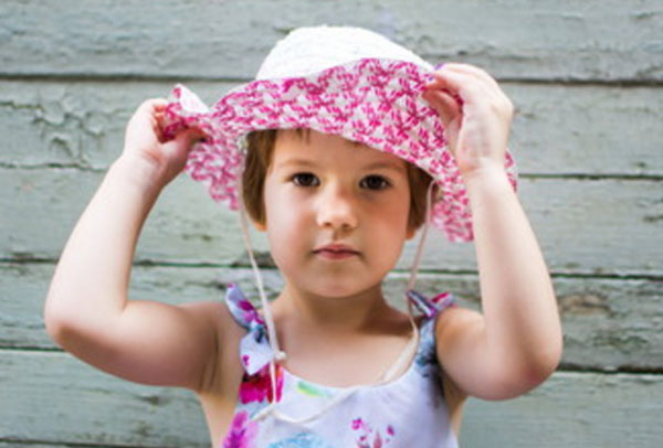 Девочка трех лет примеряет шляпку