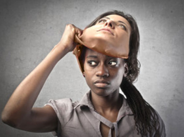 Женщина афроамериканка снимает с лица маску белой женщины