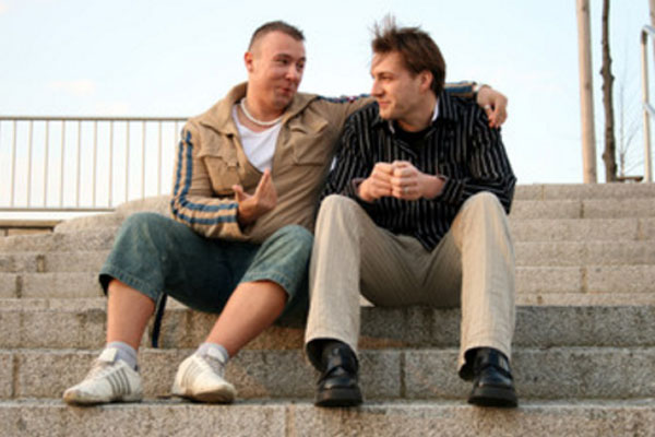 Два мужчины сидят на ступеньках и разговаривают