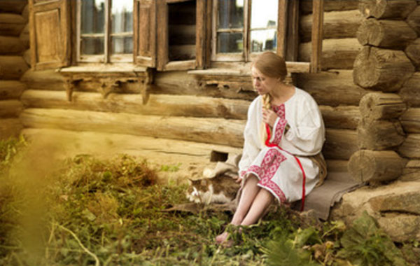 Девушка сидит возле хаты