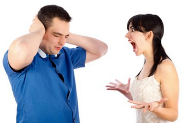 Женщина кричит на мужчину. Он закрывает уши руками